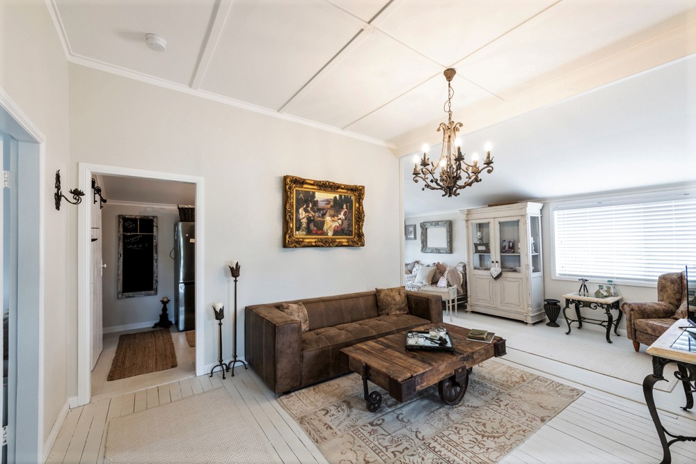 Bright living room with chandelier, leather sofa and timber coffee table, Cambridge living room redesign