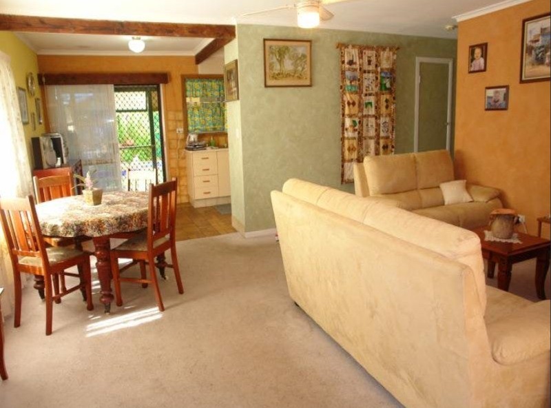Outdated living room before renovation, green walls and dated furniture, Jacaranda living room redesign