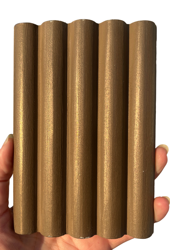 Hand-held sample of fluted bronze liquid metal finish, bespoke finish technique